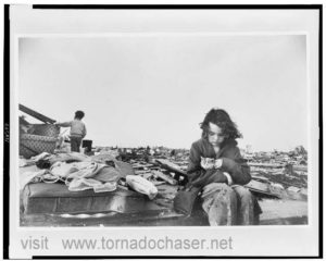 Tornado girl sits in rubble with cat